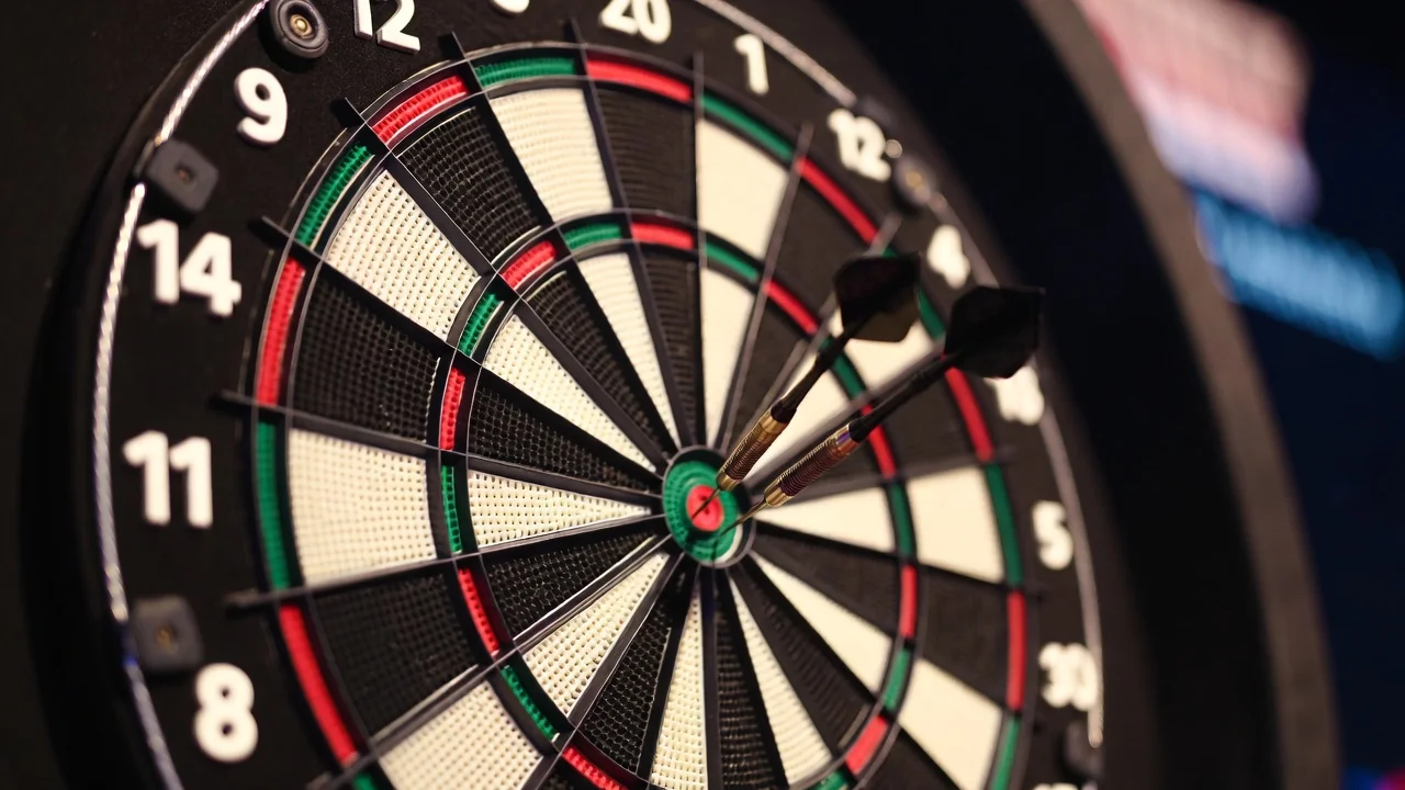 Close-up van drie dartpijlen in een dartbord bij de oche